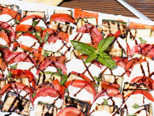Summer is definitely here and I am thrilled to see more and more local produce available. This is my favorite season for really fresh ingredients and fresh dishes like this Grilled Vegetable Caprese Salad! A fun twist on the classic, this layered dish of grilled red bell peppers, zucchini, fresh tomatoes and Stella® Fresh Mozzarella is what Summer cooking is all about! #ad #StellaCheeses